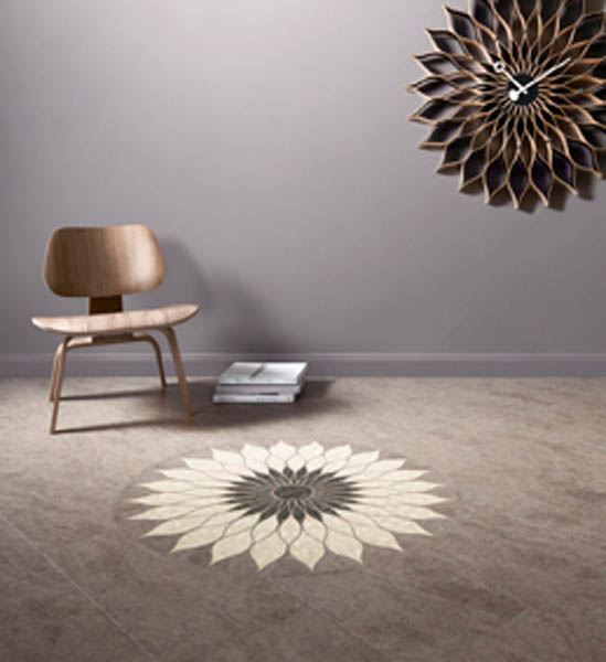 Stone-effect vinyl floor inlaid with a bespoke cream and grey sunflower medallion, below a matching wall clock.